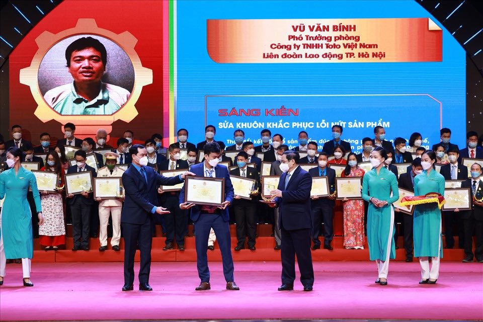 Politburo member, Prime Minister Pham Minh Chinh (right) and Party Central Committee member, President of the Vietnam General Confederation of Labor Nguyen Dinh Khang presented Certificates of Merit and emblems for advanced models in the emulation movement "75 thousand initiatives to overcome difficulties and develop" organized by the Vietnam General Confederation of Labor in 2021. Photo: Hai Nguyen