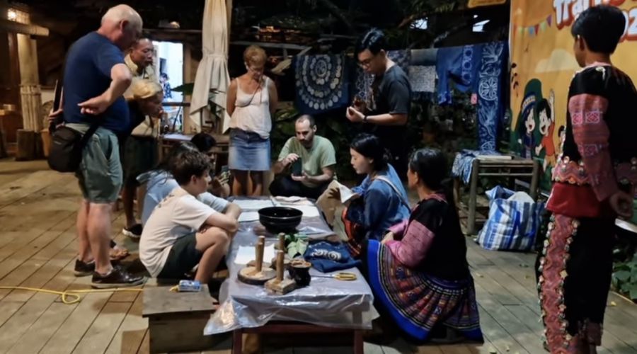 Artisans in Hua Tat village instruct foreign tourists on how to dye fabric. Photo: Character provided