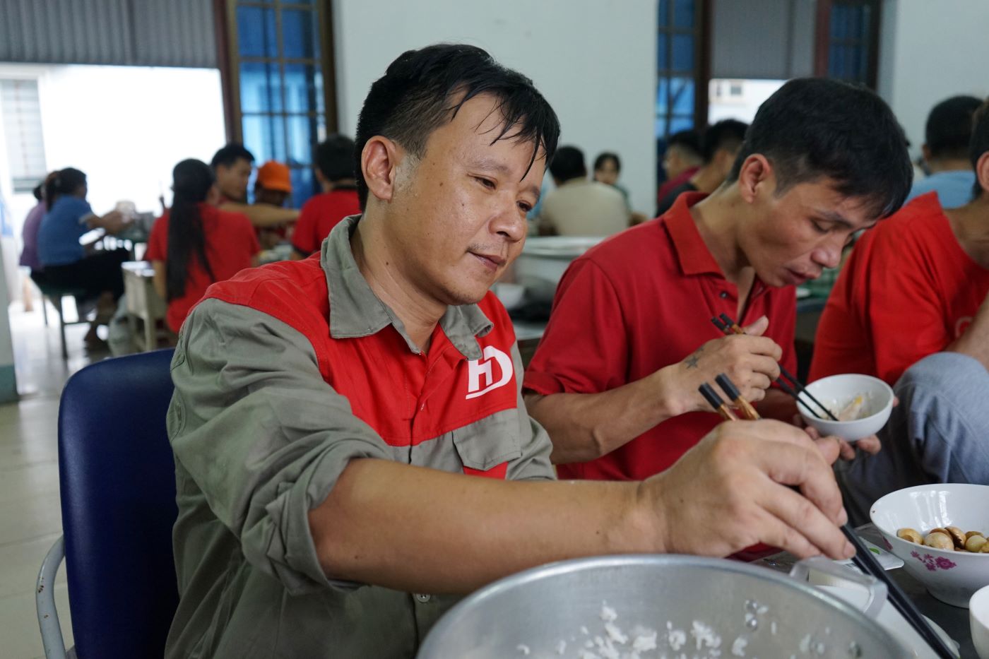 Anh Le Viet Long (cong nhan Cong ty Co phan Thiet bi Giao duc Hong Duc) vui mung du “Bua com Cong doan” va thuong thuc nhieu mon ngon. Anh: Quach Du