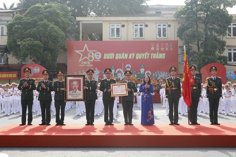 Pho Chu tich nuoc Vo Thi Anh Xuan trao Huan chuong Bao ve To quoc hang Nhi va anh chan dung Chu tich Ho Chi Minh tang Doan Nghi le Quan doi. Anh: Bo Quoc phong