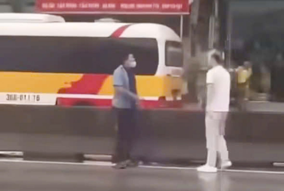 The image was cut from a clip of the bus driver asking Mr. C (in white shirt) to delete the photo but could not be chased and beaten. Source: Ngoc Anh.