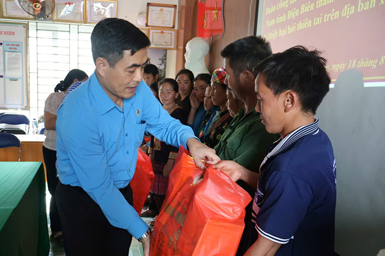 El Sr. Tan Minh Long entrega regalos para apoyar a la gente en las zonas inundadas de la comuna de Xa Dung provincia de Dien Bien. Foto: Tran Nga