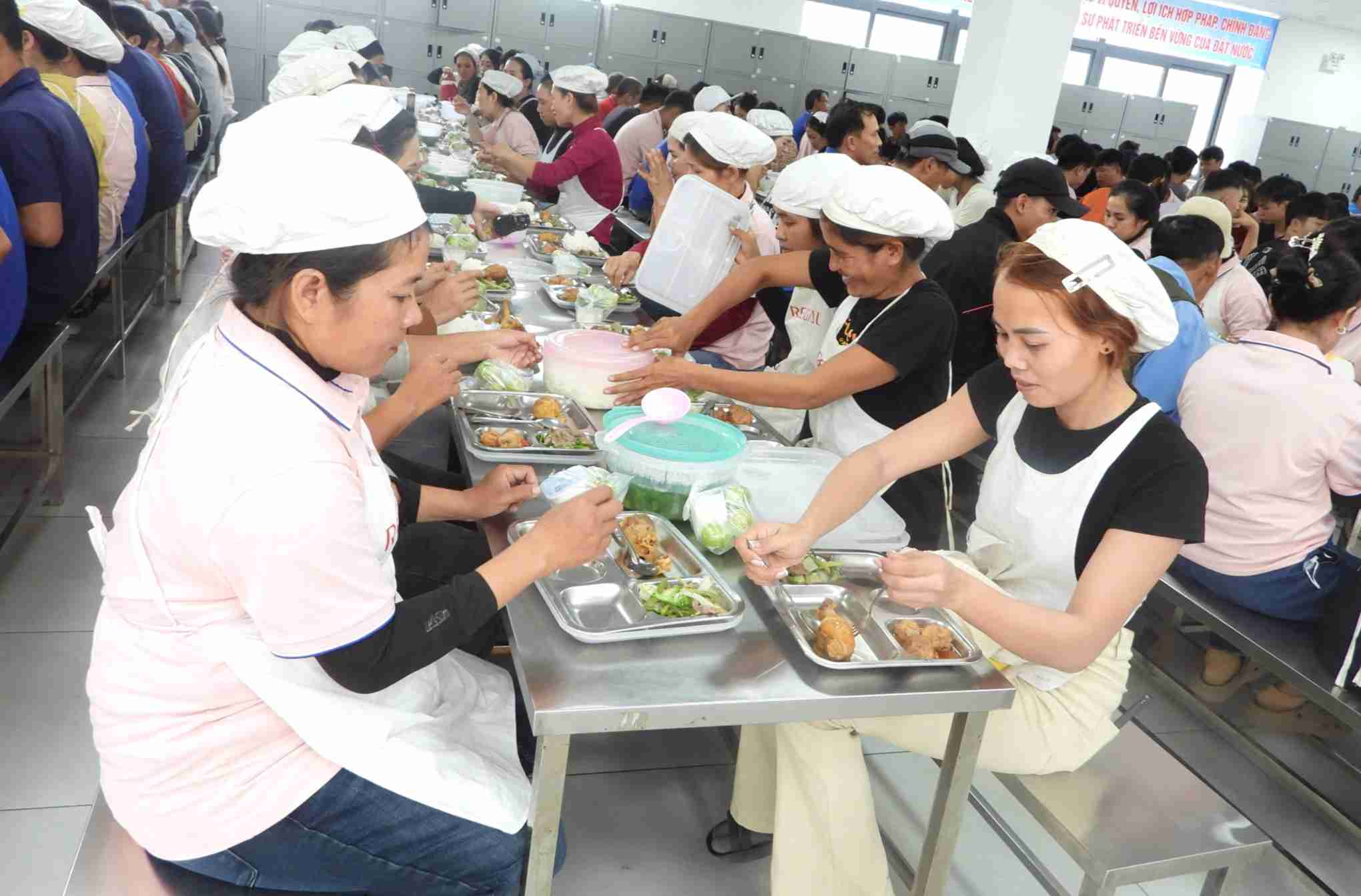Cong nhan lao dong ngoi quay quan, vui ve dung bua trua. Anh: Bao Trung