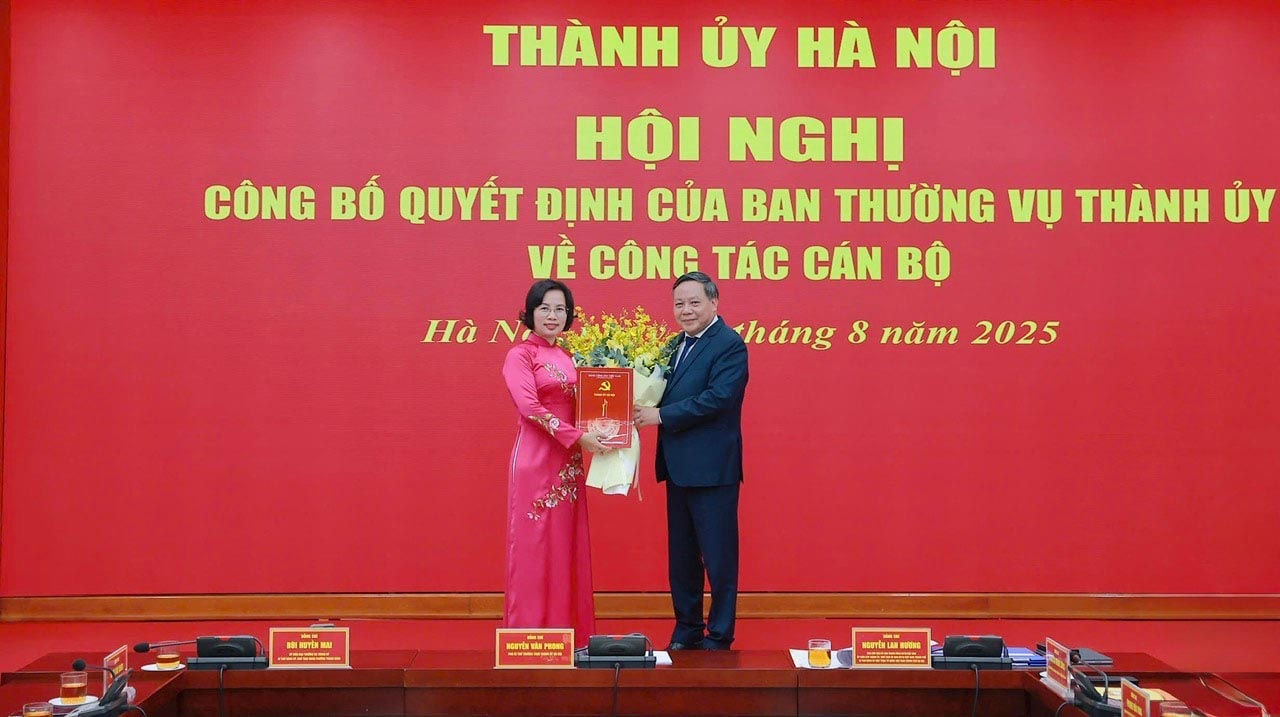 El Vicesecretario Permanente del Comite del Partido de la Ciudad de Hanoi Nguyen Van Phong entrega la decision al camarada Bui Huyen Mai. Foto: Nguyen Quang