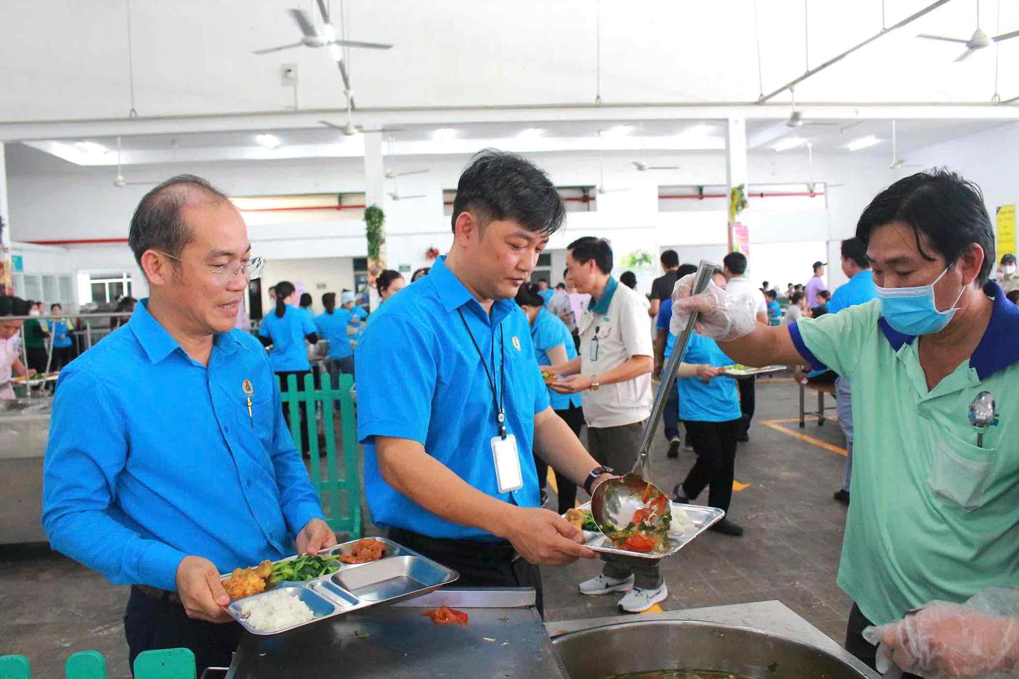 Ong Nguyen Quoc Dung (giua) - Chu tich LDLD tinh Dong Nai du Bua com Cong doan voi doan vien, nguoi lao dong.