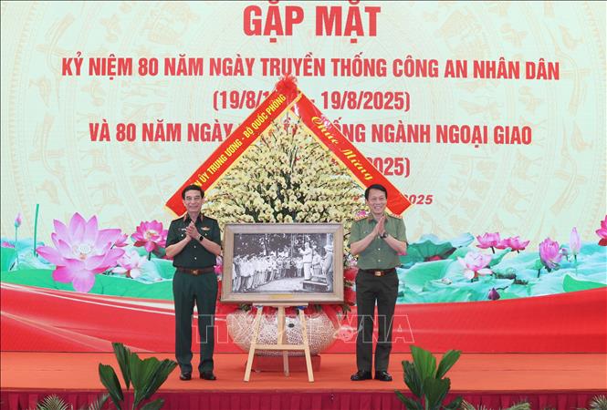 Dai tuong Phan Van Giang, Uy vien Bo Chinh tri, Pho Bi thu Quan uy Trung uong, Bo truong Bo Quoc phong tang buc anh “Chu tich Ho Chi Minh tham don vi Canh sat nhan dan Thu do ngay 14/02/1961” cho Dai tuong Luong Tam Quang, Uy vien Bo Chinh tri, Bi thu Dang uy Cong an Trung uong, Bo truong Bo Cong an. Anh: Thong Nhat/TTXVN