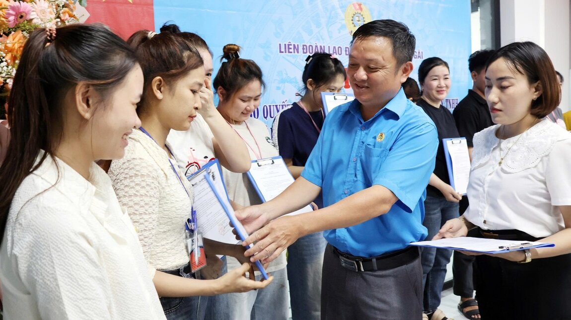 M. Le Thanh Binh membre du Comite permanent de la Federation provinciale du travail remet la decision de reconnaissance du Comite executif du syndicat de base de la societe a responsabilite limitee Hui Feng Sports Materials New Materials Technology. Photo : Syndicat de Quang Ngai