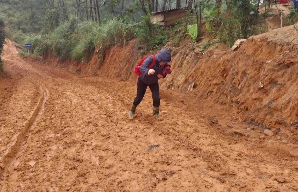 Bajo la lluvia las carreteras resbaladizas dificultan el paso por ellas una maestra que iba a la escuela Ta Cu a enseñar se cayo y tuvo que vendarse las piernas durante todo un mes. Foto: H.Nguyen