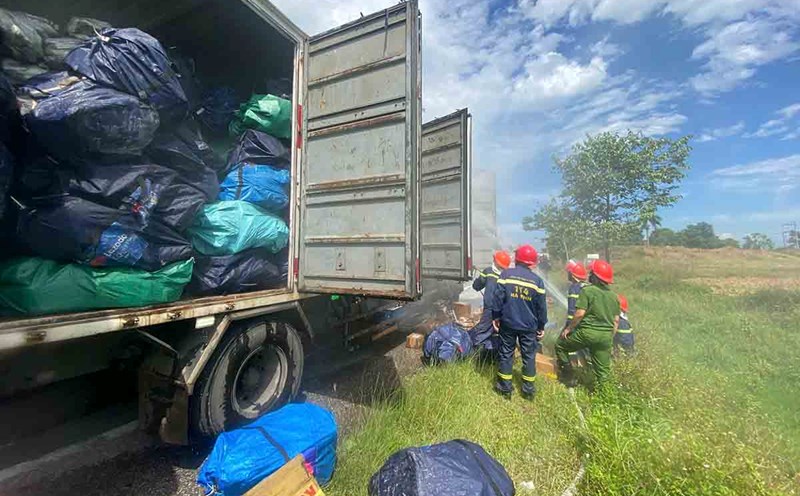 The police tried to put out the fire to rescue the goods on the post office truck. Photo: Tuan Loc