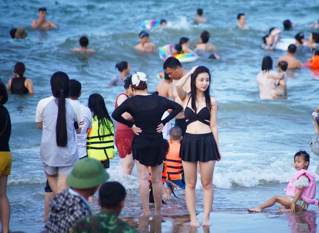 Los turistas disfrutan experimentando el mar de Cua Lo (Nghe An). Foto: Duy Chuong