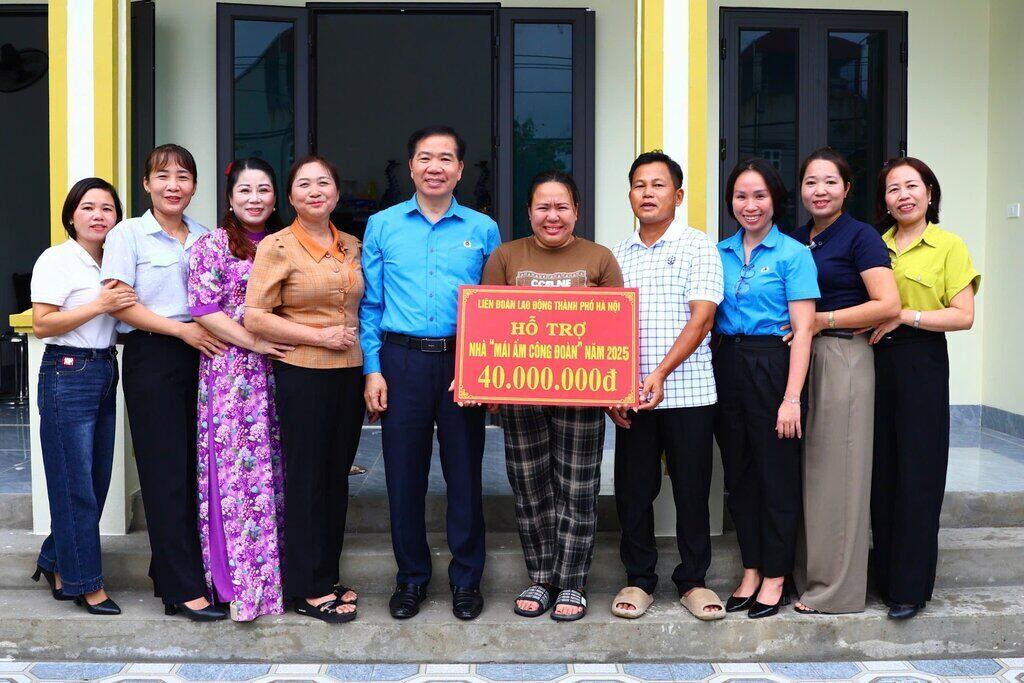 Dinh Thi Yen 씨(오른쪽에서 다섯 번째)가 노동조합의 집 건설 자금 지원을 받고 감동하고 있습니다. 사진: Manh Quan