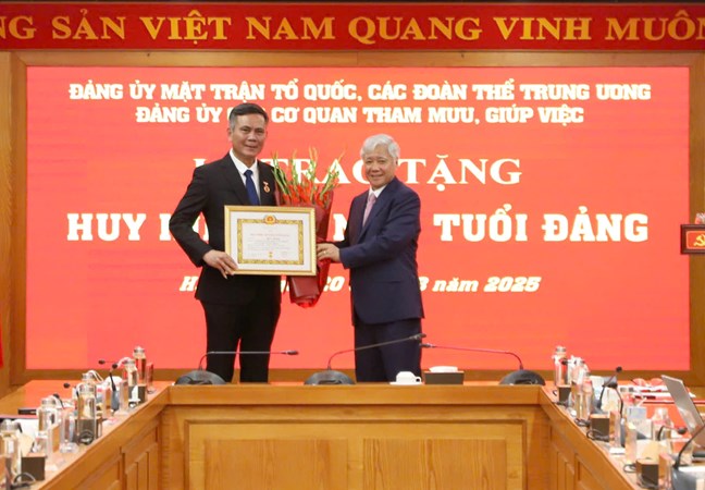 El camarada Do Van Chien miembro del Buro Politico Secretario del Comite Central del Partido Secretario del Comite del Partido del Frente de la Patria de las Asociaciones Centrales Presidente del Comite Central del Frente de la Patria de Vietnam entrega la Medalla de 30 años de militancia en el Partido al camarada Tran Thang Subsecretario del Comite del Partido del Frente de la Patria de las Asociaciones Centrales. Foto: Minh Hien