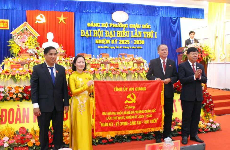 Bi thu Tinh uy An Giang Nguyen Tien Hai ((bia phai anh) tang Dai hoi buc truong co noi dung: Doan ket - Dan chu - Dot pha- Phat trien“. Anh: Lam Dien
