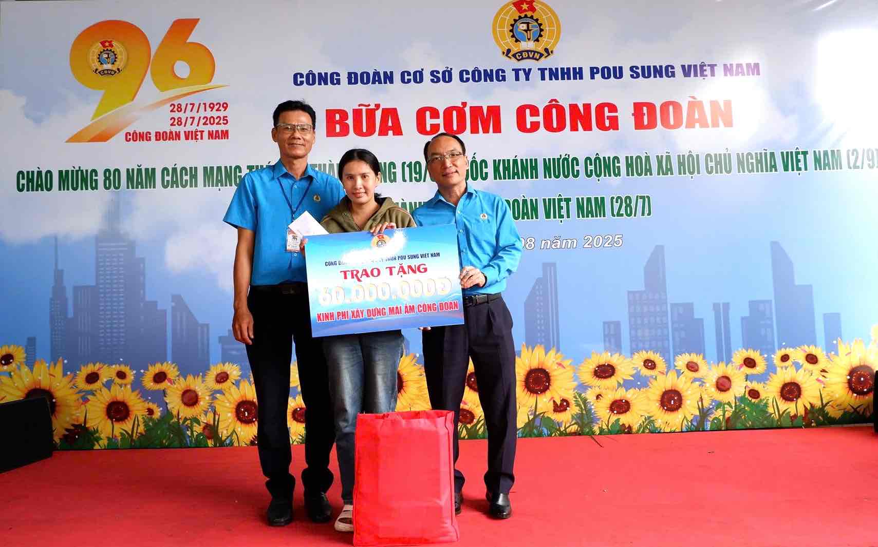 Ong Nguyen Duc Thang - Pho Chu tich LDLD tinh Dong Nai (ben phai) va Chu tich Cong doan co so Cong ty TNHH Pou Sung Viet Nam Le Nhat Truong trao Mai am Cong doan cho doan vien kho khan. Anh: Cong doan cong ty