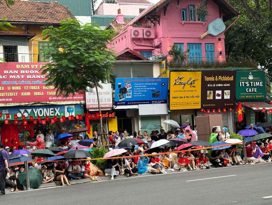 At 4:00 p.m. this afternoon, August 21, it rained on Nguyen Thai Hoc Street. People and tourists quickly opened their umbrellas, wore raincoats and continued to wait for the parade. Photo: Nguyen Dat