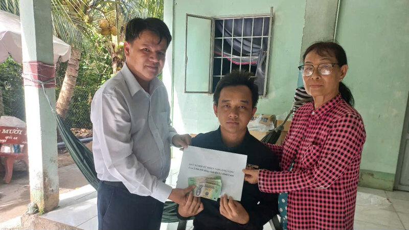 Chang trai 26 tuoi Le Minh Luan cung me nhan ho tro tu Quy Xa hoi Tu thien Tam long Vang. Anh: Hoang Loc