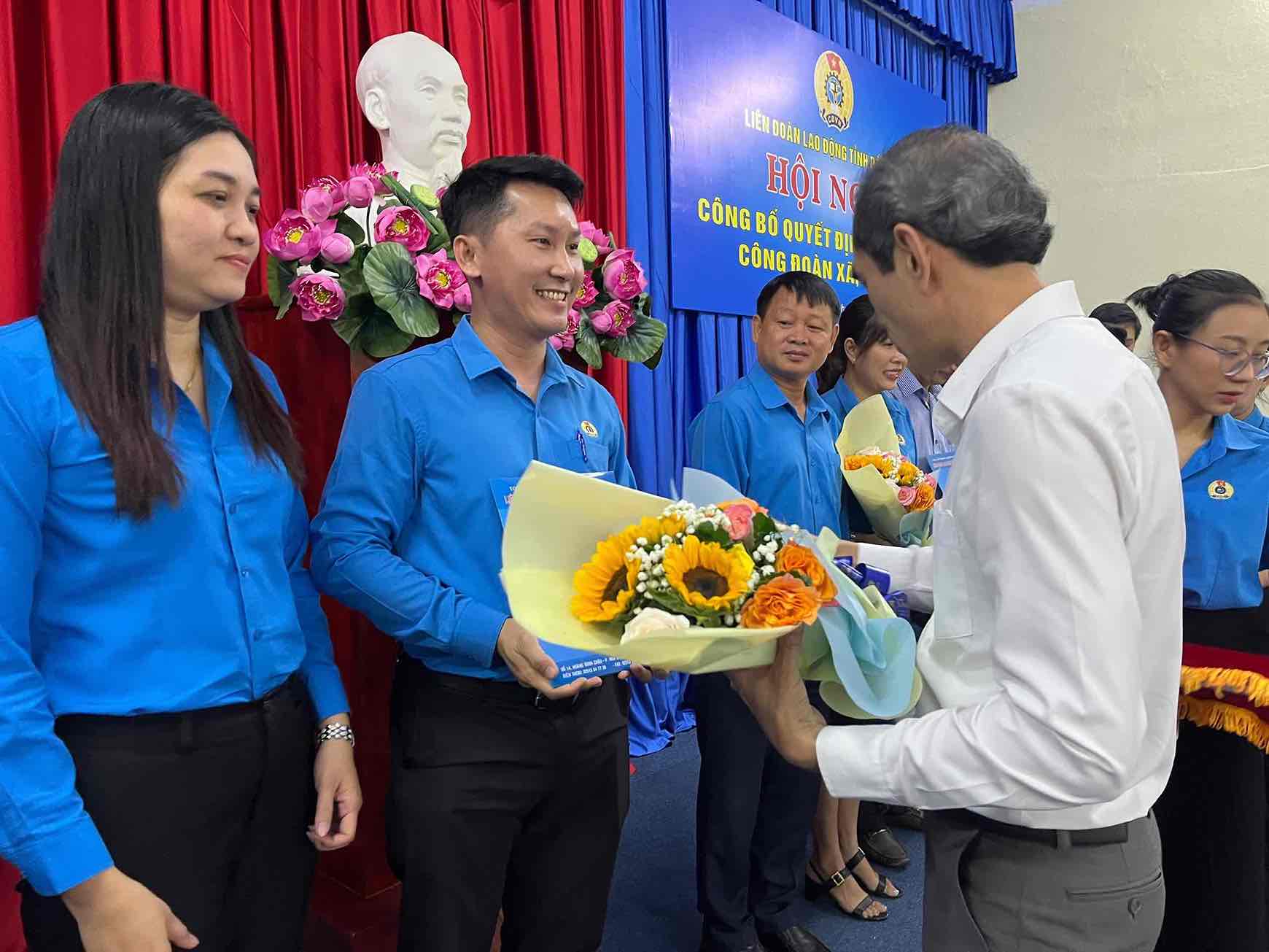 Pho Chu tich Uy ban MTTQVN tinh Dong Nai Nguyen Tat Do trao hoa chuc mung Chu tich Cong doan phuong Tran Bien. Anh: HAC