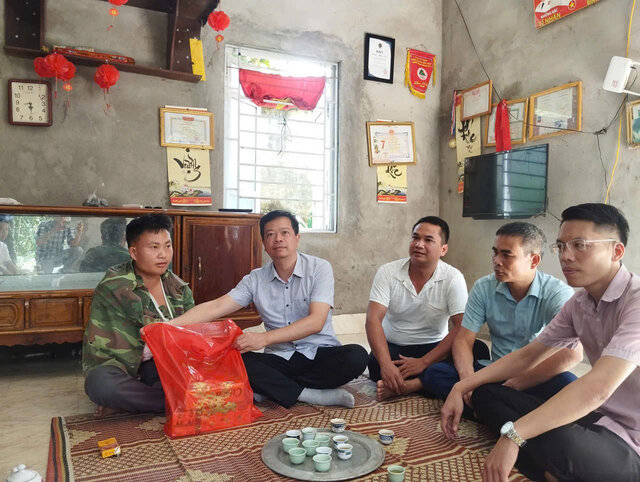 Lanh dao xa Toan Thang tham hoi, dong vien anh Bui Anh Tho - nguoi bi chan thuong khi di xu ly xac lon troi noi tren suoi. Anh: UBND xa Toan Thang