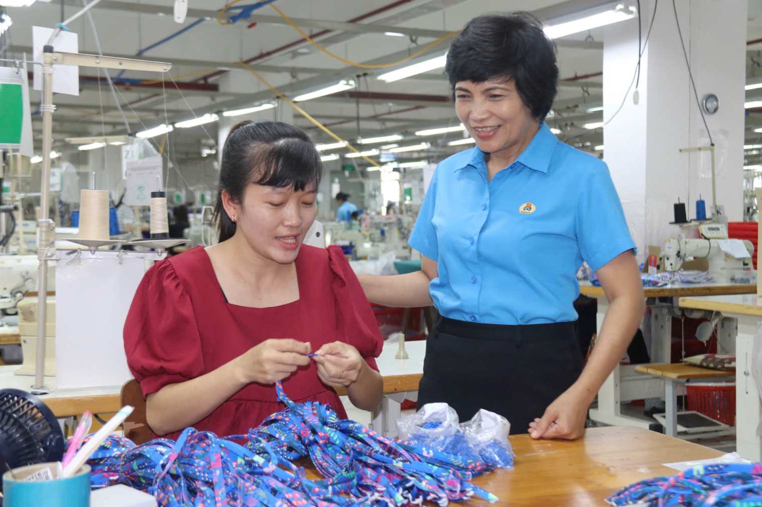 쩐 티 흐엉 카인호아성 노동총연맹 부위원장이 프랑스식 베트남 여성 의류 개발 유한회사에서 근무하는 조합원을 방문하고 있습니다. 사진: 프엉 린