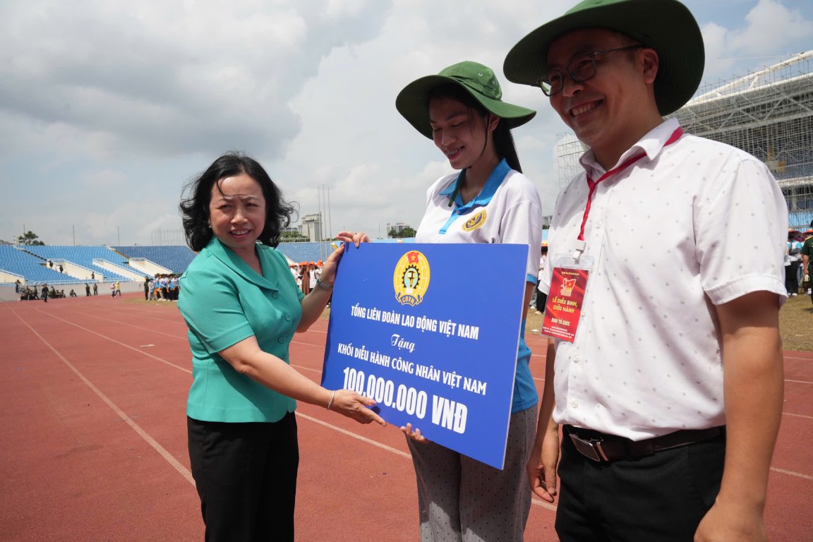 타이 투 쓰엉 베트남 노동총연맹 상임 부위원장이 베트남 노동자 행진 블록에 선물을 전달하고 있습니다. 사진: 흐우 찬