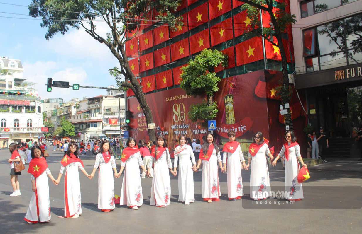 Buc tuong rao bao quanh cong truong pha do toa nha Ham Ca Map (cu) da duoc trang tri bang hang chuc la co To quoc kho lon, tro thanh boi canh chup anh moi cua nguoi dan va du khach.