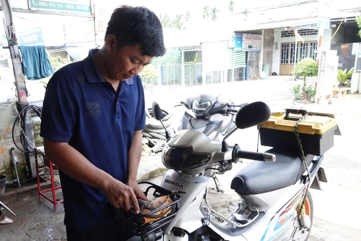 Anh Phuc ben chiec xe may cua minh. Anh: Ta Quang
