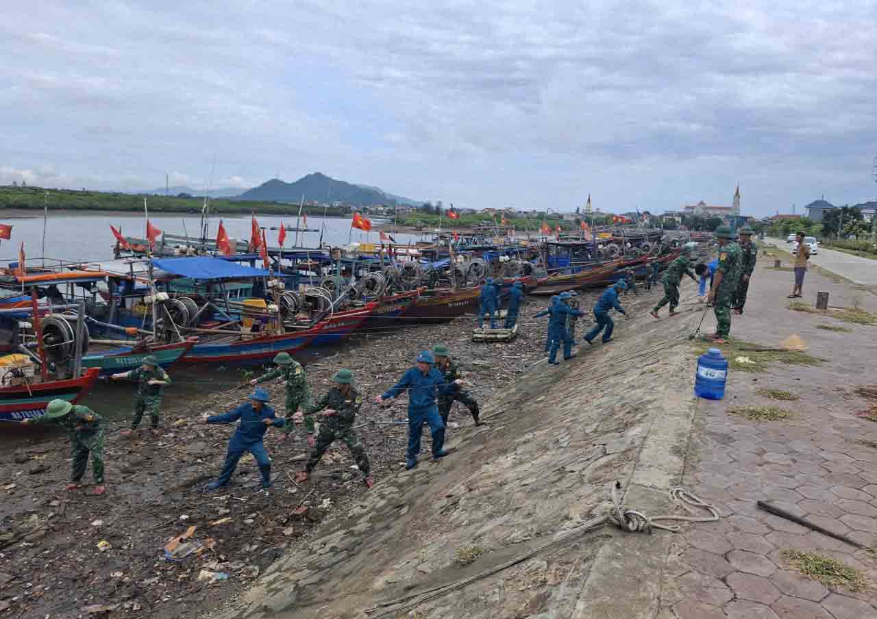 Bo doi Bien phong va Dan quan tu ve giup ngu dan keo, neo tau thuyen tai Khu tranh tru bao Cua Sot. Anh: Tran Tuan.