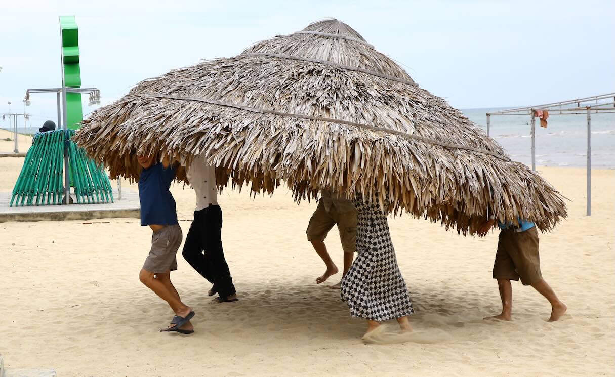 People at Nhat Le 1 beach carry tourist cages ashore to avoid storm No. 5. Photo: Cong Sang