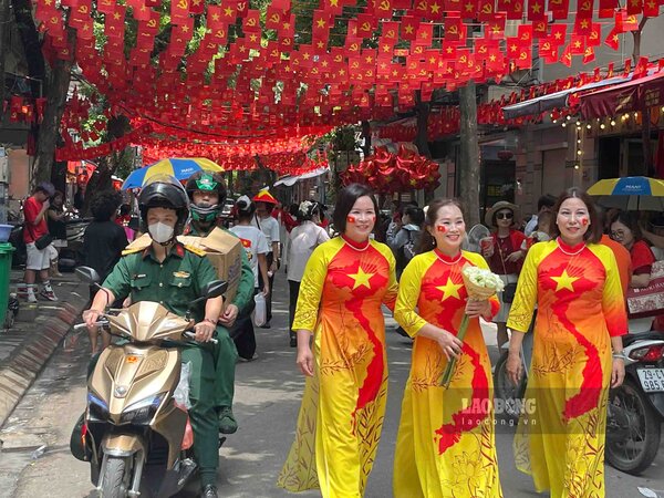Nguoi dan chup anh luu niem tren pho Phan Dinh Phung trong luc cho doan dieu binh di qua. Anh: Van Truong