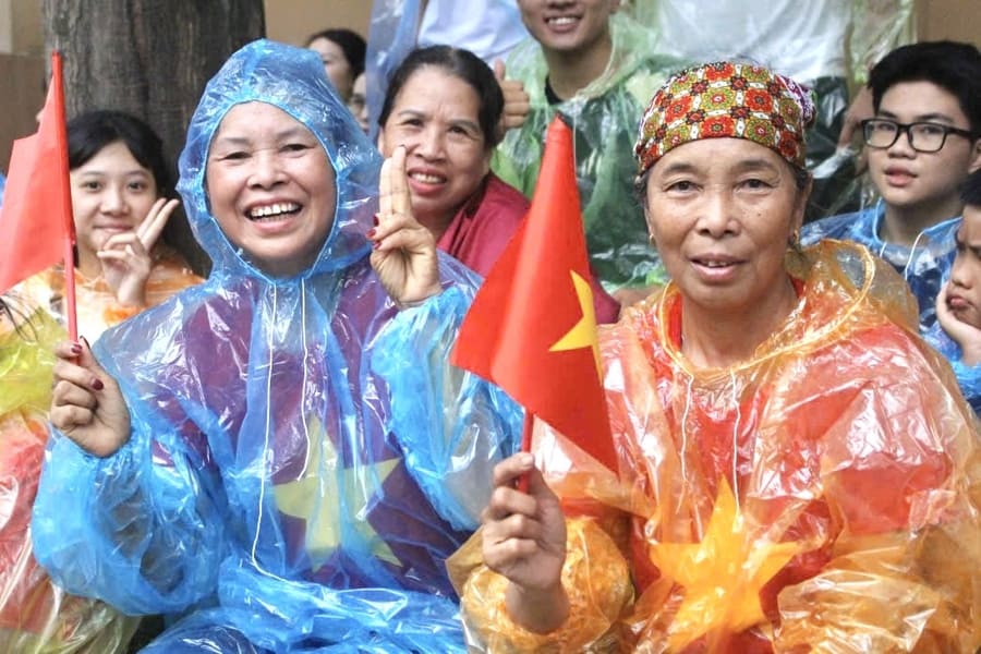 People wear raincoats to wait half a day to watch the parade on August 24. Photo: Le Tuyen