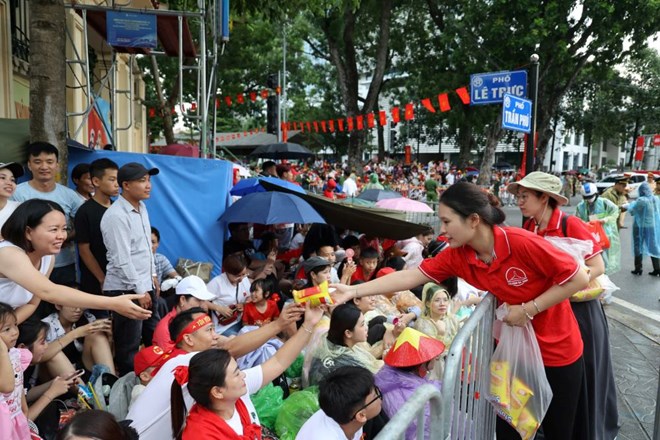 Nguoi dan va du khach duoc ho tro do an khi di xem tong hop luyen dieu binh, dieu hanh ngay 24.8. Anh: Pham Dong