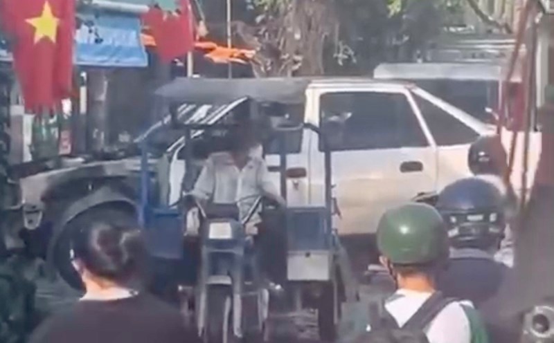 Image of a three-wheeled vehicle driver carrying an old car causing traffic congestion and being fined. Photo: Dong Hoang