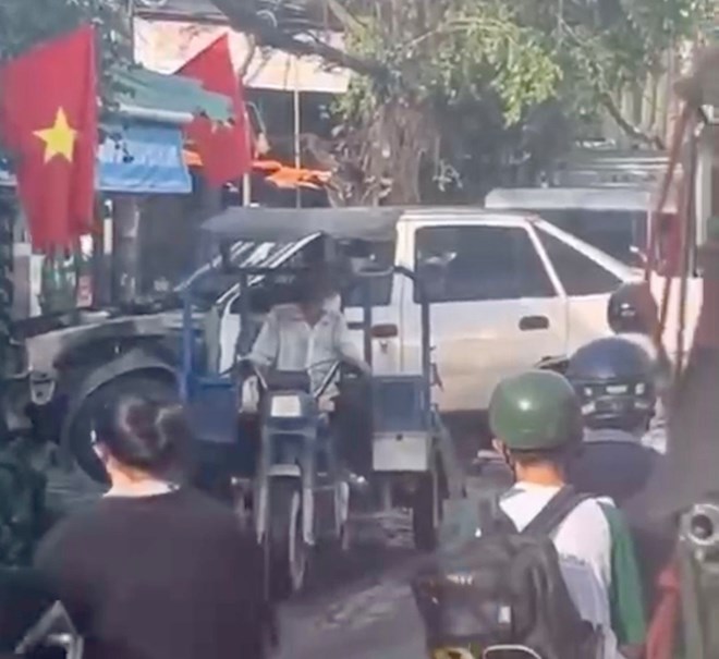 Hình ảnh tài xế xe ba gác chở xác ôtô cũ gây ùn tắc giao thông, bị xử phạt. Ảnh: Đông Hoàng