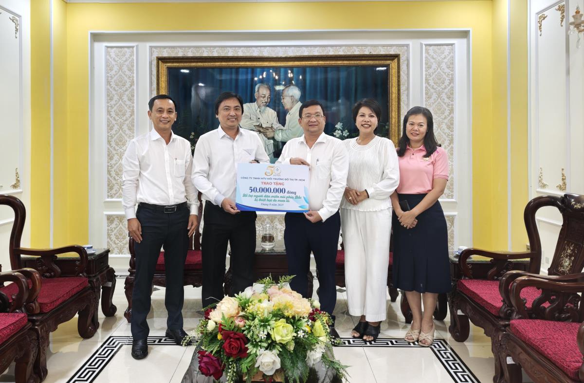 Doan dai bieu Cong ty TNHH Moi truong do thi TPHCM trao bang ung ho dong bao cac tinh bi thiet hai boi thien tai. Anh: Anh Hoang