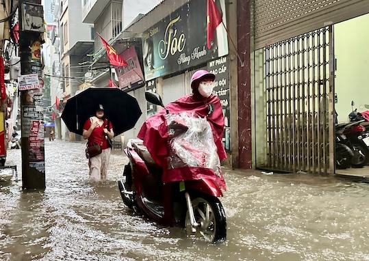 Theo ghi nhan cua phong vien, khu vuc dg Me Tri, Phuong Tu Liem ngap khoang 20cm. Mot so phuong tien bi chet may khien nguoi dan phai dat bo di qua cho duong ngap. Anh: Tuan Anh.