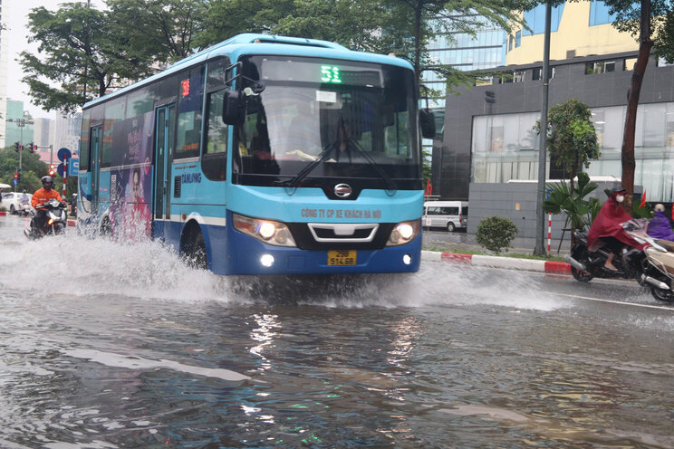 Nhieu khu vuc tren pho Pham Van Bach bi ngap cuc bo, cac phuong tien phai di chuyen sat con luon de tranh bi ngap nuoc. Anh: Nguyen Linh