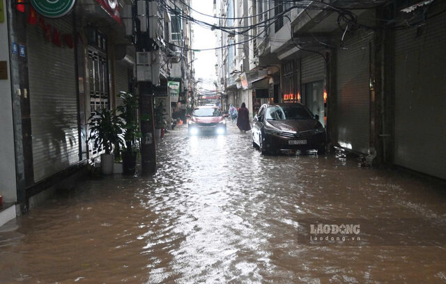 Luc 8h30, tai khu do thi Goldmark City (phuong Phu Dien, TP Ha Noi), anh huong cua bao so 5 tu dem 25.8 den sang 26.8 da khien nhieu tuyen duong, pho xung quanh khu do thi tren chim trong bien nuoc. Mua lon keo dai khien nguoi dan phai bi bom qua nhung doan duong, pho ngap. Anh: Thanh Nhan