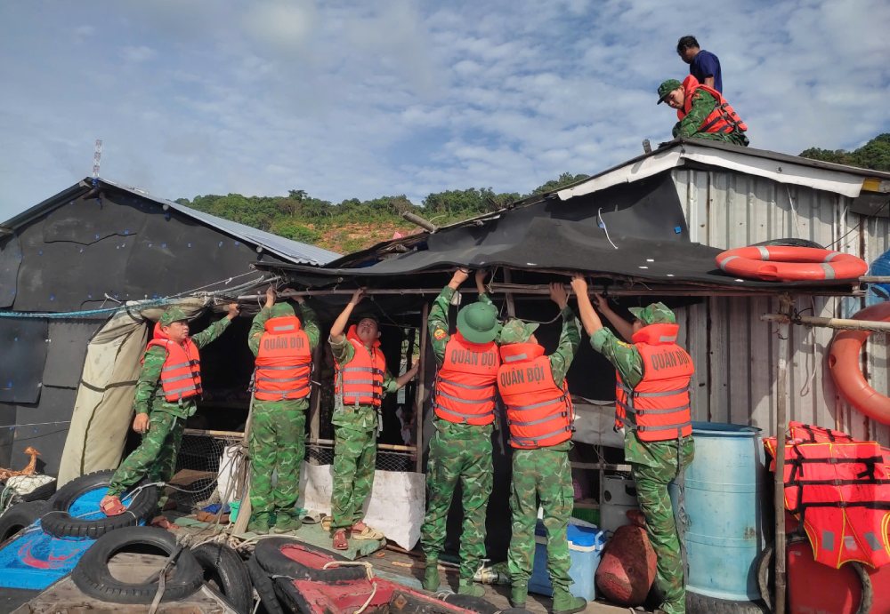Des fonctionnaires et des soldats du poste de garde-frontiere de Tho Chau aident les habitants a etrangler leurs maisons. Photo : Tien Vinh