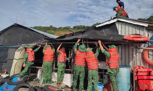 Cán bộ, chiến sĩ Đồn Biên phòng Thổ Châu giúp dân chằng buộc lại nhà cửa. Ảnh: Tiến Vinh