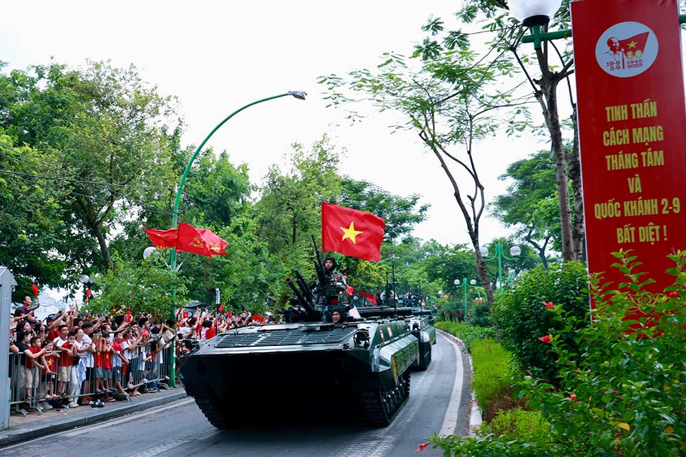 Residentes y turistas saludan a los soldados de la marcha militar en el desfile hacia el punto de reunion en la sesion de entrenamiento general en Hanoi. Foto: Hai Nguyen