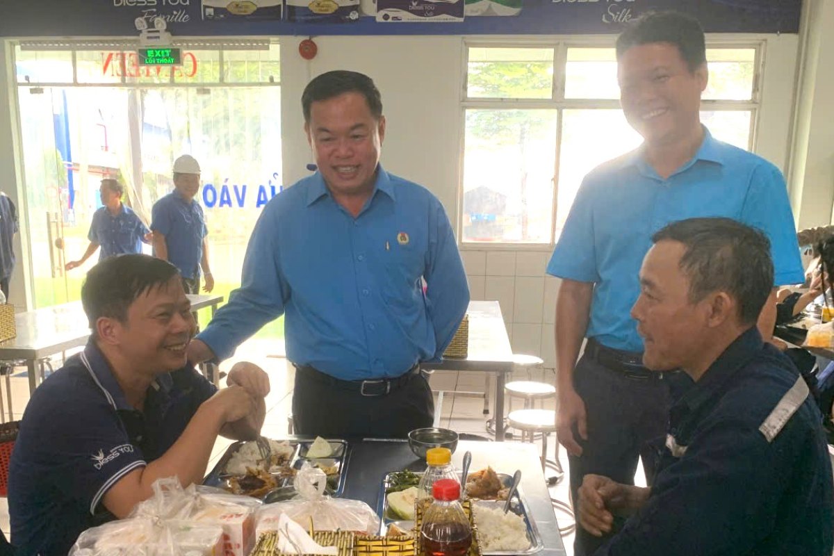 Nguyen Ba Hung 씨(왼쪽에서 두 번째 칸)가 노동조합 점심 식사에서 노동자들을 격려하며 칸을 교환하고 있습니다. 사진: Vinh Loc