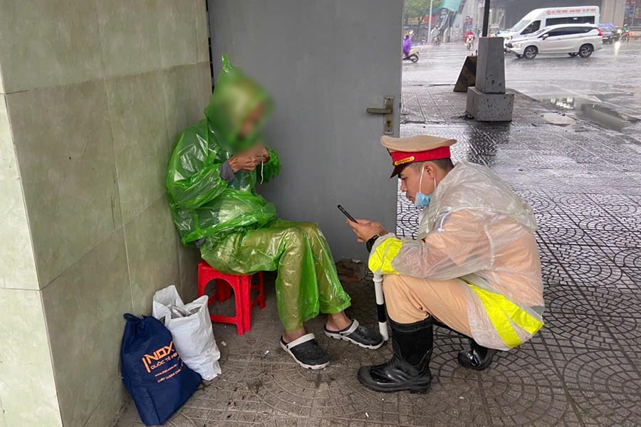 CSGT mac ao mua cho cu ong de phong giam than nhiet va tim kiem thong tin gia dinh. Anh: Cong an cung cap