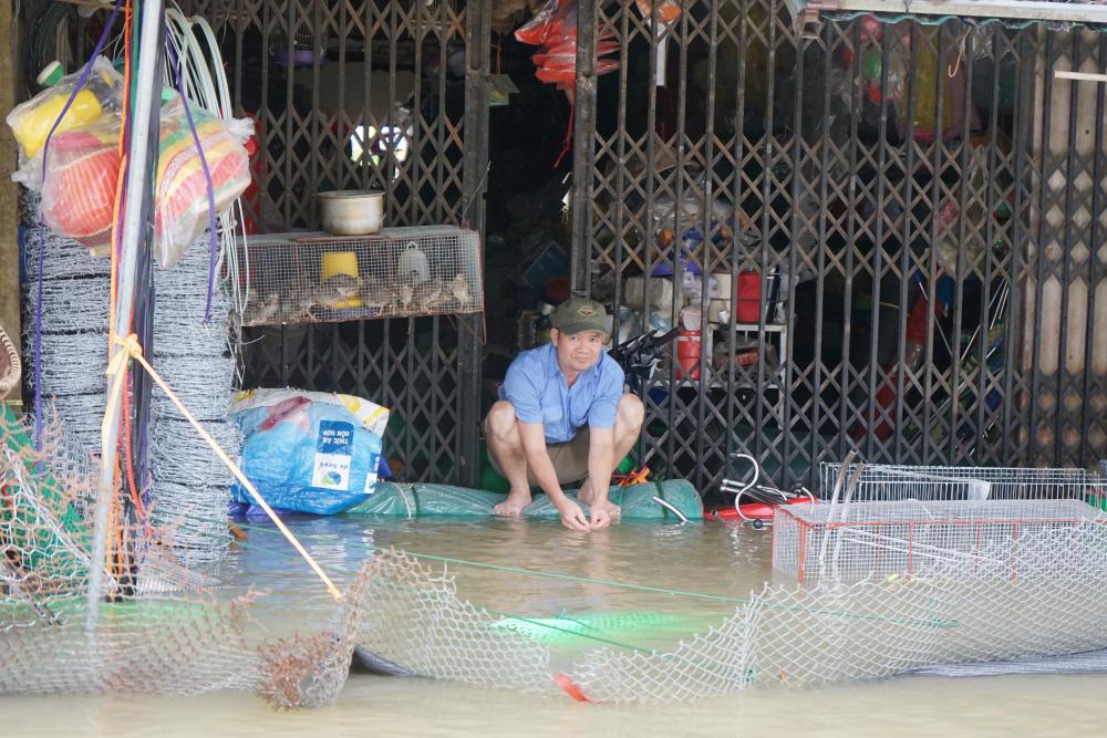 Nuoc lu ngap sau vao cac cua hang, khien nguoi dan gap nhieu kho khan. Anh: Quach Du