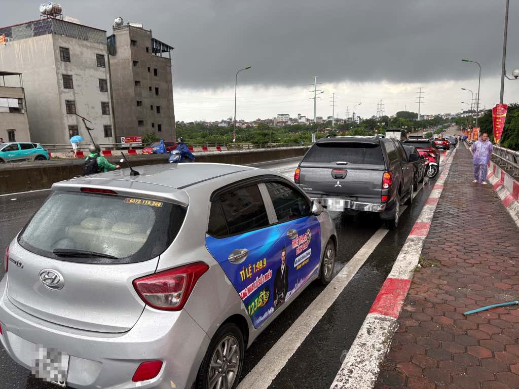 Nhiều ô tô đỗ trên cầu vượt đường sắt Yên Nghĩa để tránh đoạn đường ngập nước. Ảnh: Bảo Hân 