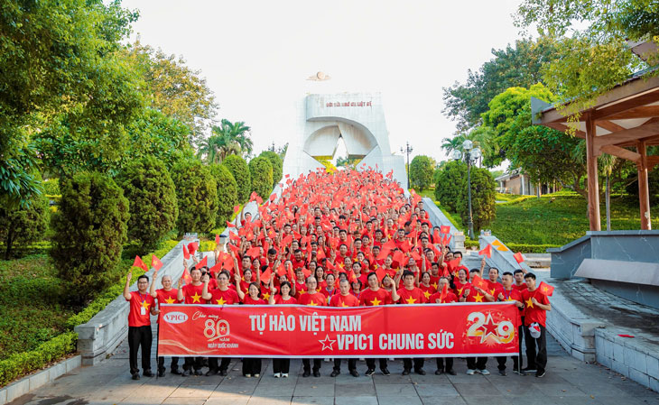 Cong nhan, nguoi lao dong Cong ty TNHH cong nghiep chinh xac Viet Nam trong trang phuc ao do sao vang tham du le chao co. Anh: An Vi