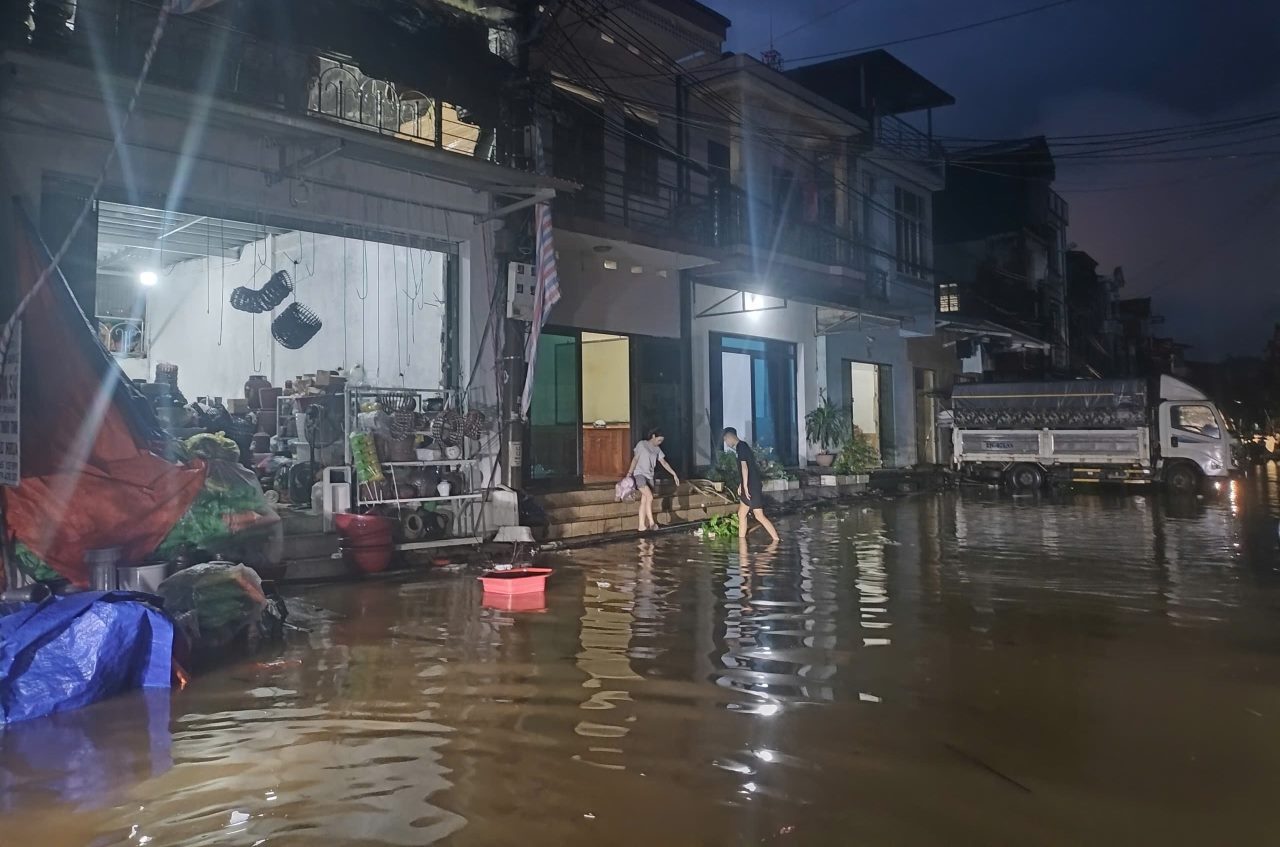 Nguoi dan tat bat don do, di chuyen tai san de chay lu. Anh: Van Duc.