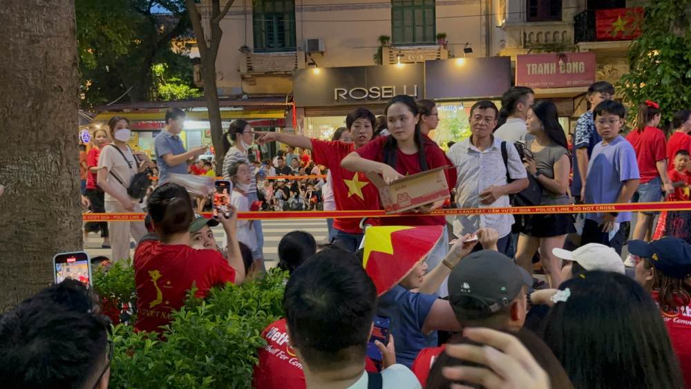 Quynh Anh - wife of midfielder Duy Manh gave food to people watching the parade. Photo: Nguyen Dat