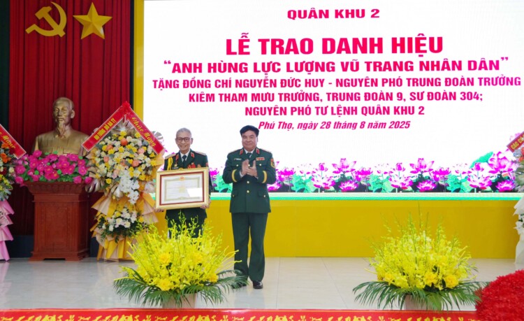 Trung tuong Pham Duc Duyen trao danh hieu “Anh hung Luc luong vu trang nhan dan” tang Thieu tuong Nguyen Duc Huy. Anh: Quan khu 2