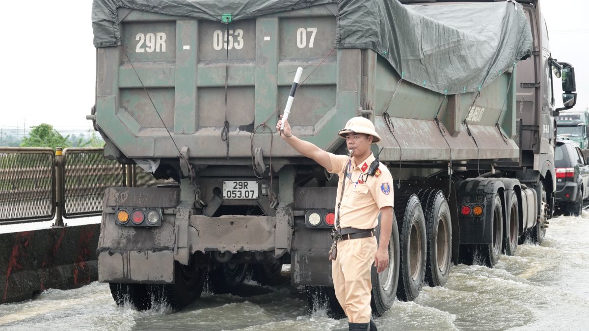 Luc luong CSGT dieu tiet, phan luong cac phuong tien qua doan duong bi ngap. Anh: Quach Du