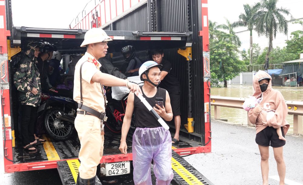Truoc tinh trang tren, chien si CSGT Thanh Hoa da phai de nghi xe tai (loai xe chuyen dung cho o to) ho tro, giup xe may qua doan duong ngap. Anh: Quach Du